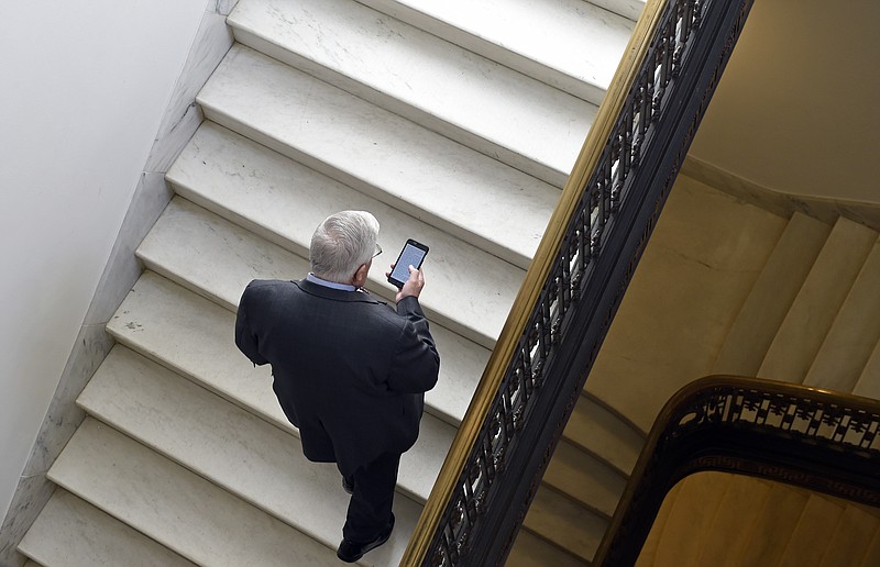 FILE - In this Feb. 4, 2015, file photo, Sen. Mike Enzi, R-Wyo., checks his phone as he arrives for a bipartisan lunch in the Kennedy Caucus Room on Capitol Hill in Washington. Oregon Sen. Ron Wyden is proposing new legislation that would allow the Senate’s Sergeant at Arms to spend taxpayer money protecting senators’ private email accounts and personal devices amid persistent anxieties over the digital security of the American midterm vote. (AP Photo/Susan Walsh, File)