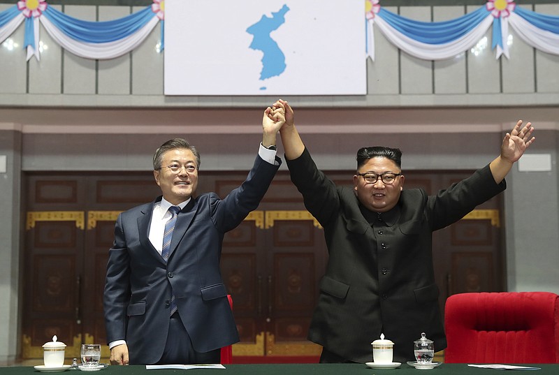 South Korean President Moon Jae-in and North Korean leader Kim Jong Un raise their hands after watching the mass games performance of "The Glorious Country" at May Day Stadium in Pyongyang, North Korea, Wednesday, Sept. 19, 2018. (Pyongyang Press Corps Pool via AP)