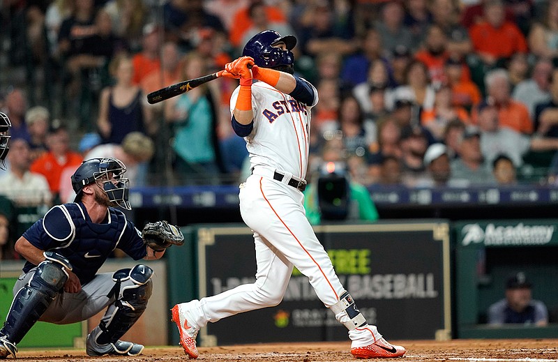 Houston Astros' Marwin Gonzalez, right, hits a two-run home run as Seattle Mariners catcher Chris Herrmann watches during the third inning of a baseball game Tuesday, Sept. 18, 2018, in Houston. (AP Photo/David J. Phillip)