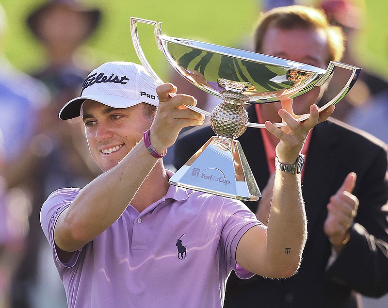 In this Sept. 24, 2017, file photo, Justin Thomas holds the trophy after winning the Fedex Cup after the Tour Championship golf tournament at East Lake Golf Club in Atlanta. The bonus pool for the PGA Tour season doubles next year to $70 million in a revamped system that pays $15 million to the FedEx Cup champion. (Curtis Compton/Atlanta Journal-Constitution via AP, File)