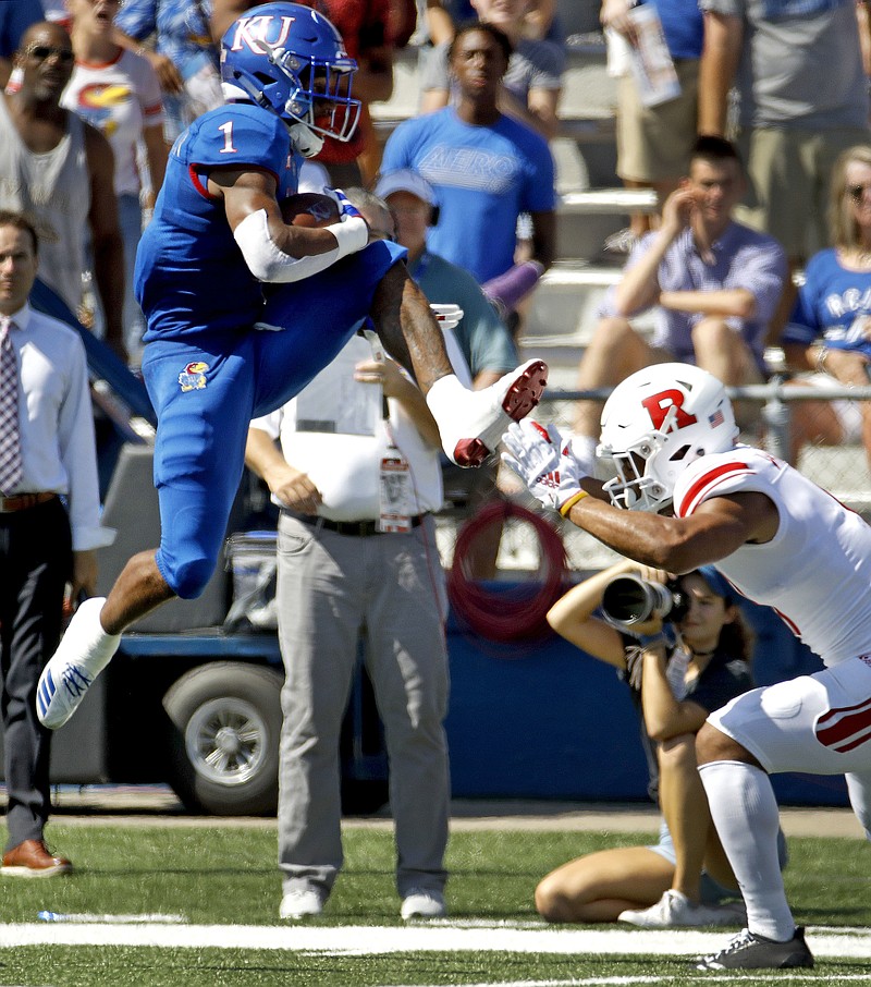 Kansas running back Pooka Williams Jr. (1) leaps over Rutgers defensive back Isaiah Wharton (11) as he runs the ball during the first half of an NCAA college football game Saturday, Sept. 15, 2018, in Lawrence. (AP Photo/Charlie Riedel)