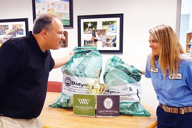 Fulton employees and Stream Team participants Darin Wernig, left, and Courtney Coffelt want to start a friendly rivalry between Westminster College and William Woods University. The student body that collects the most bags of trash this school year wins a trophy.