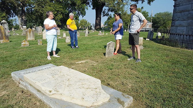 Cemetery Resources Board commissioner Nancy Thompson, left, speaks to fellow commissioners Jeanne Rutledge, Dawn Hackman and Tim Theroff on Thursday about the Sarah Walker tabletstone the commission restored earlier this year. Sarah Walker is the wife of former Missouri state Treasurer John G. Walker and niece of President Andrew Jackson.