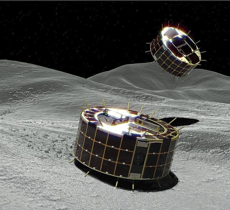 This computer graphic image provided by the Japan Aerospace Exploration Agency (JAXA) shows two drum-shaped and solar-powered Minerva-II-1 rovers on an asteroid. Japanese unmanned spacecraft Hayabusa2 released two small Minerva-II-1 rovers on the asteroid Ryugu on Friday, Sept. 21, 2018, in a research effort that may provide clues to the origin of the solar system. JAXA said confirmation of the rovers' touchdown has to wait until it receives data from them on Saturday. (JAXA via AP)