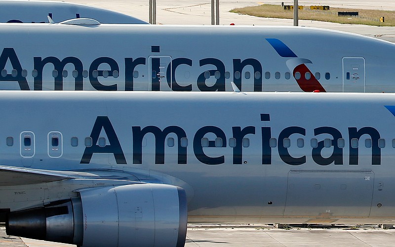 In this Nov. 6, 2017, file photo, a pair of American Airlines jets are parked on the airport apron at Miami International Airport in Miami. American Airlines is threatening to prohibit customers from making changes to nonrefundable tickets if Congress makes good on a proposal to crack down on unreasonable airline fees. American CEO Doug Parker says his airline would be acting just like many other businesses when customers want to swap their ticket for a different flight or for another day. "We - like the baseball team, like the opera - would say, 'We're sorry, it was nonrefundable,'" Parker said this week.  (AP Photo/Wilfredo Lee, File)