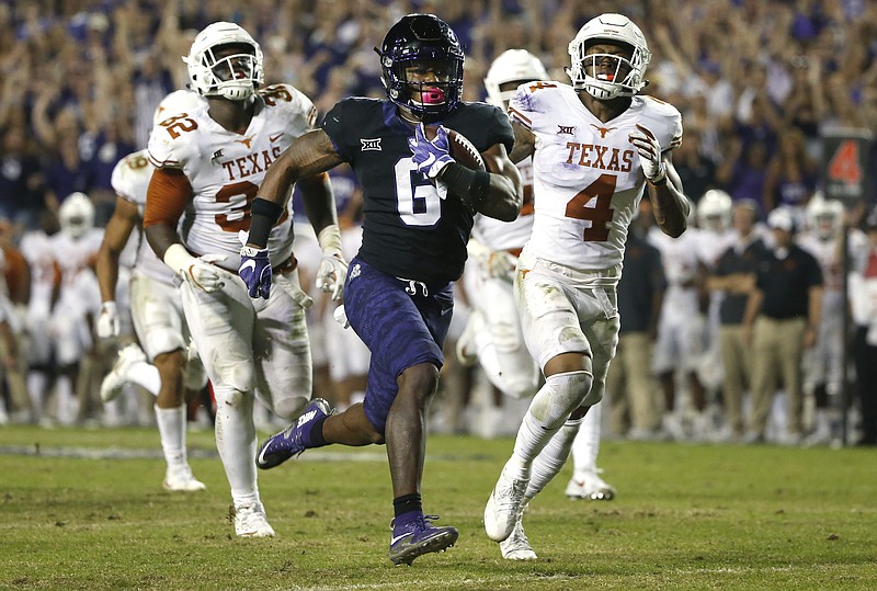 In this Nov. 4, 2017, file photo, TCU running back Darius Anderson (6) runs for a touchdown as Texas defenders Malcolm Roach (32) and DeShon Elliott (4) pursue during the second half of an NCAA college football game in Fort Worth, Texas. The Longhorns are looking to prove they're back and end a run of domination by Big 12 rival No. 17 TCU on Saturday.  (AP Photo/Ron Jenkins, File)