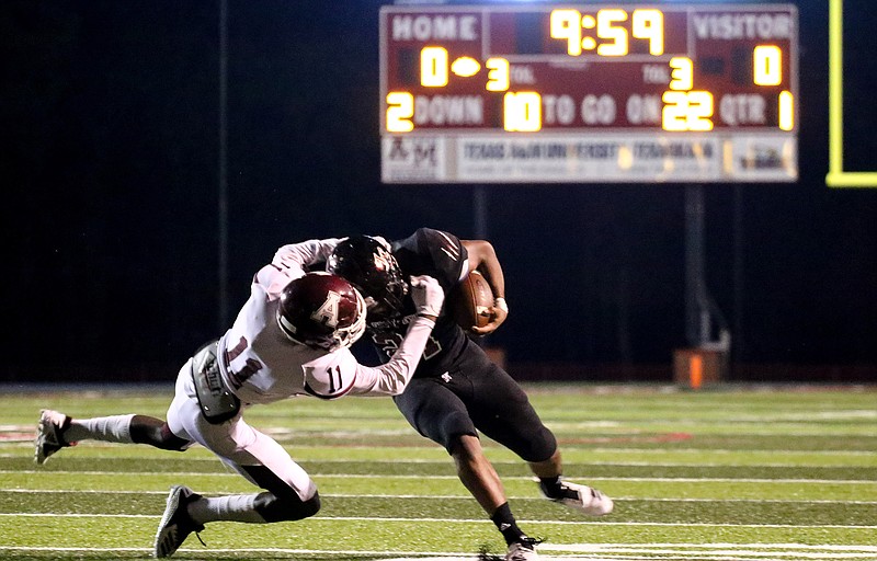 Liberty-Eylau running back Damian Henderson (21) blocks Atlanta's J.J. Fields (11) while rushing downfield Friday at Harris Field.