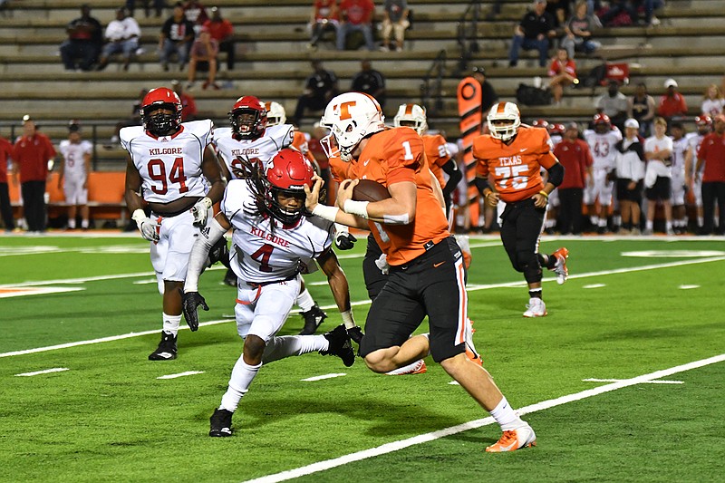 Texas High quarterback Coltin Clack (1) tries to keep Kilgore defender Nesba Brown (4) at arm's length to avoid the sack and pick up yardage for the Tigers on Friday at Tiger Stadium at Grim Park. (Photo by Kevin Sutton)
