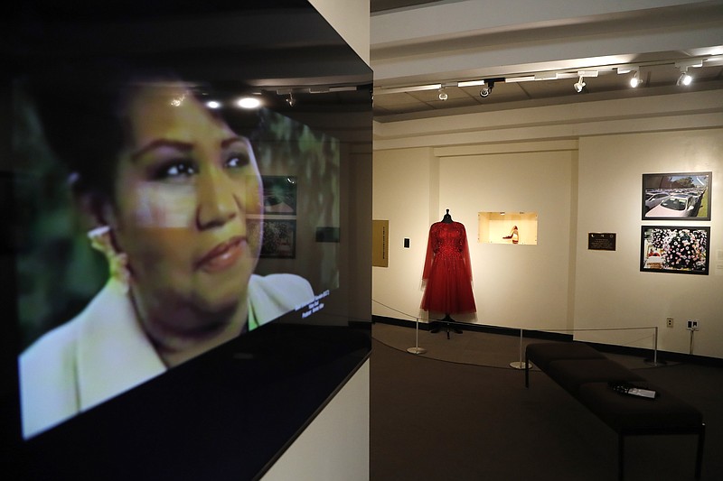 In a photo from Friday, Sept. 21, 2018, in Detroit, an exhibit at the Charles H. Wright Museum of African American History features a "tribute to the Queen of Soul." "THINK" opens to the public Tuesday at the museum that hosted Aretha Franklin's public visitations after her death last month. It features archival photographs, videos and the red shoes she wore at her first visitation that drew global attention. (AP Photo/Carlos Osorio)