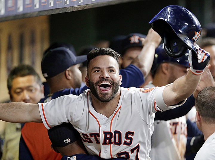 Houston Astros' Jose Altuve is lifted up by Tony Kemp in the dugout in celebration of his two-run home run against the Los Angeles Angels during the eighth inning of a baseball game Saturday, Sept. 22, 2018, in Houston. (AP Photo/Michael Wyke)