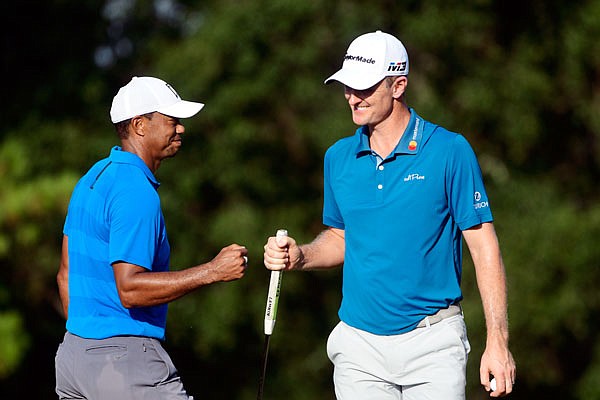 Tiger Woods and Justin Rose fist bump on the 16th green during Saturday's third round of the Tour Championship in Atlanta.