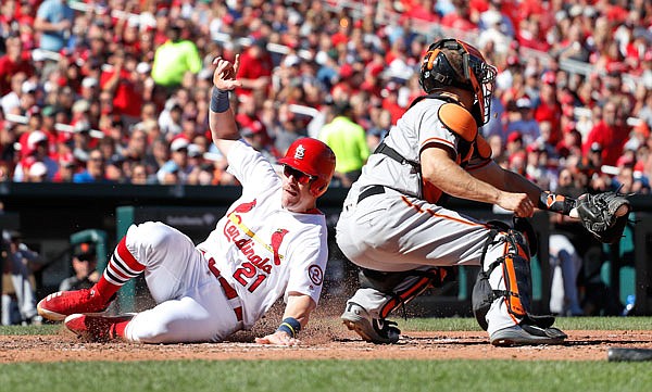Patrick Wisdom of the Cardinals scores past Giants catcher Nick Hundley during the sixth inning of Sunday afternoon's game at Busch Stadium in St. Louis.
