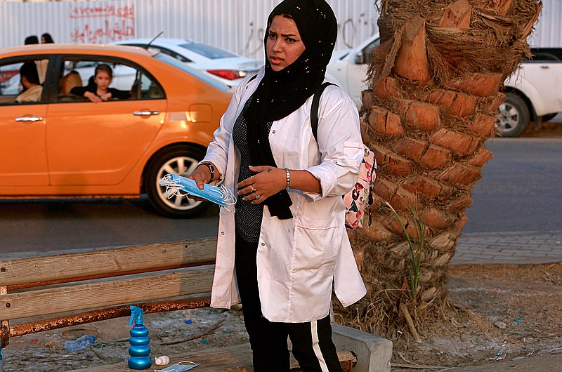 Hajar Youssif, an Iraqi activist and volunteer medic who was kidnapped, beaten and threatened for attending protests, waits Tuesday, Sept. 18, 2018, with first aid supplies at a protest in Basra, Iraq. Activists say powerful Iran-backed militias that control Iraq's oil capital of Basra have waged a campaign of intimidation and arbitrary arrests to silence protests aimed at poor government services and Tehran's outsized influence in the region.