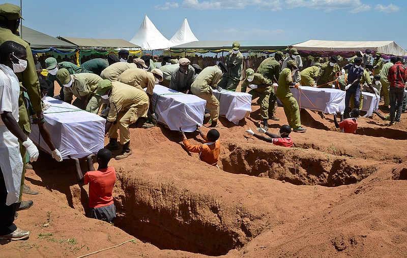 Coffins of some of the victims of the MV Nyerere passenger ferry capsizing are laid into graves during a mass burial ceremony on Ukara Island, Tanzania, Sunday, Sept. 23, 2018. Burials started Sunday of the more than 200 people who died when the ferry capsized on Lake Victoria, while the country's Defense Minister said no further survivors were likely to be found and search efforts had ended. (AP Photo/Andrew Kasuku)