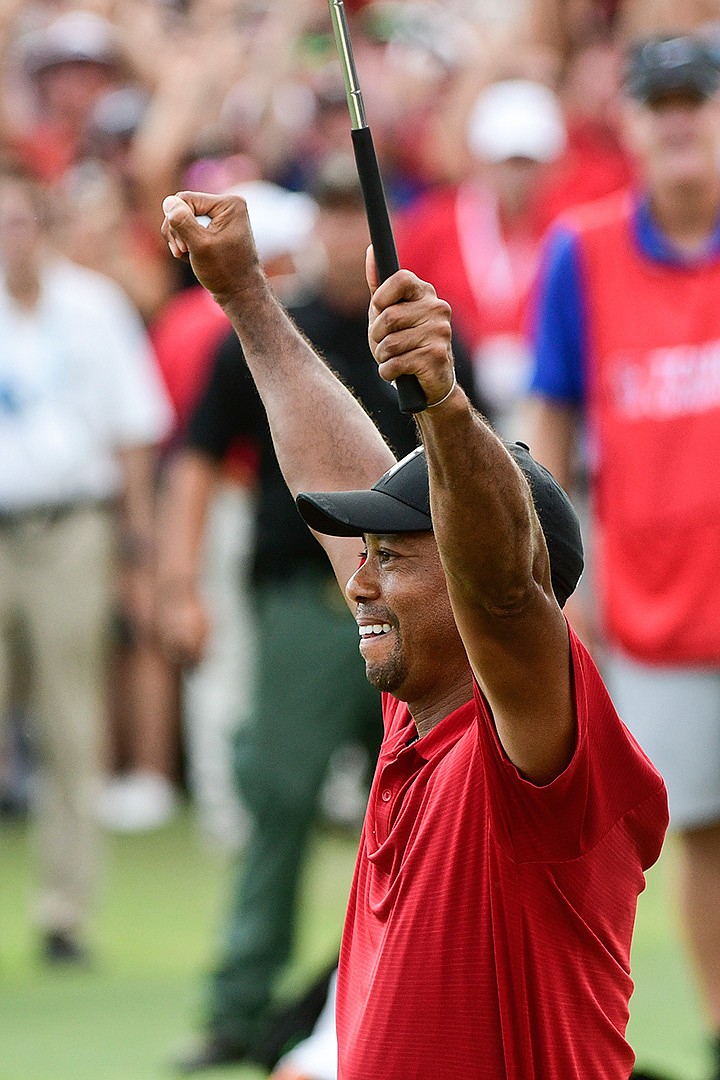  Tiger Woods celebrates after picking up his putt for par on the 18th green to win the final round of the Tour Championship golf tournament Sunday in Atlanta.