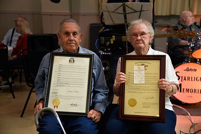 Charlie and Nettie Johnson, of Fulton, hold up a resolution presented to them under the Missouri State Senate on Saturday at the American Legion in Jefferson City. The couple celebrated their 70th anniversary in June.