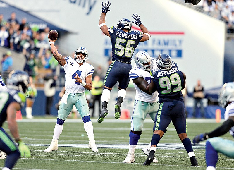 Seattle Seahawks linebacker Mychal Kendricks (56) leaps as Dallas Cowboys quarterback Dad Prescott (4) attempts a pass during the second half Sunday in Seattle.