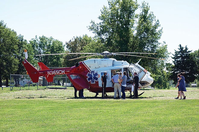 A helicopter crew from Staff for Life visited Sunday with St. Peter Fall Festival event goers. In the black pants with the side stripes are flight Nurse Gary Vogel  and pilot Ted Clemons. The event also included hay rides, bounce houses and food.