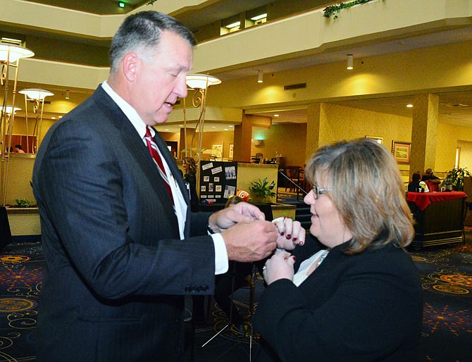 Jefferson City Public Schools Superintendent Larry Linthacum helps Distinguished Alumni Winner Stephanie Johnson with her name tag Tuesday during the JCPS Foundation Gala at the Capitol Plaza Hotel and Convention Center.