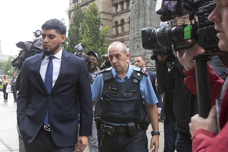 Houston Astros' Roberto Osuna, left, leaves a Toronto court, Tuesday, Sept. 25, 2018. The former Toronto Blue Jays pitcher agreed to a peace bond that led to the withdrawal of an assault charge against him. He was charged in May with assault in a domestic violence case. (Chris Young/The Canadian Press via AP)