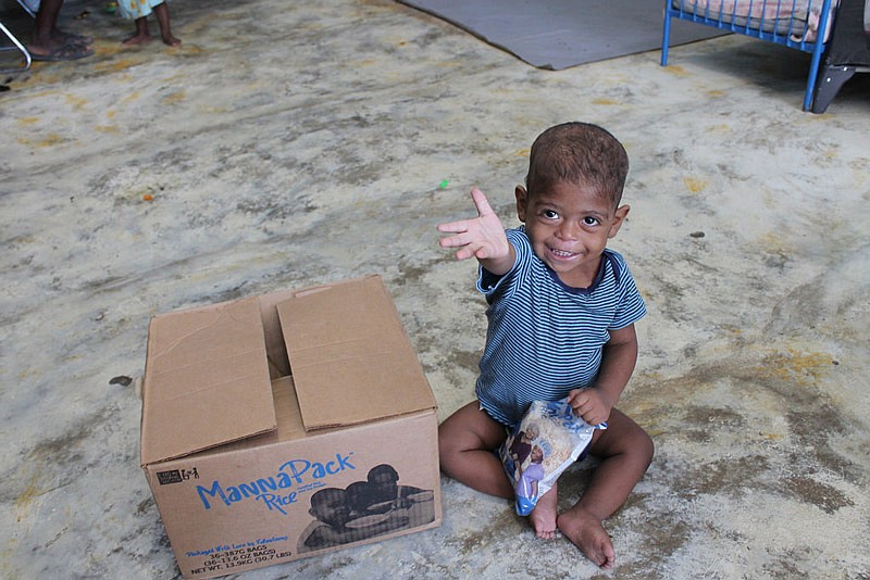 This undated photo supplied by the Feed My Starving Children organization shows the recipient of a donated pack of rice in Haiti.