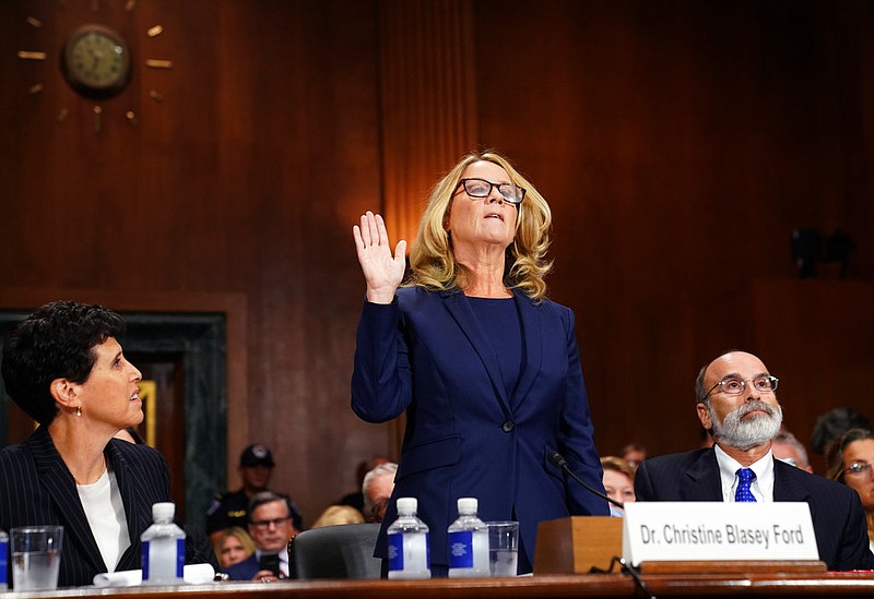 Christine Blasey Ford is sworn in to testify before the Senate Judiciary Committee on Capitol Hill in Washington, Thursday, Sept. 27, 2018. Her attorney's Debra Katz and Michael Bromwich watch. 