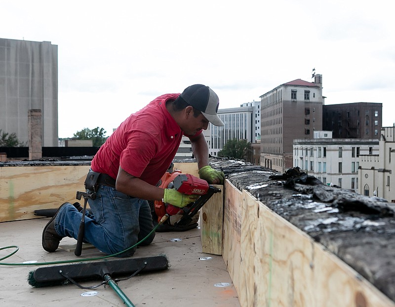 Felipe Colorado from Tony Langford Roofing works on installing a new roof Wednesday at Joe's Pizza & Pasta in Texarkana, Ark.