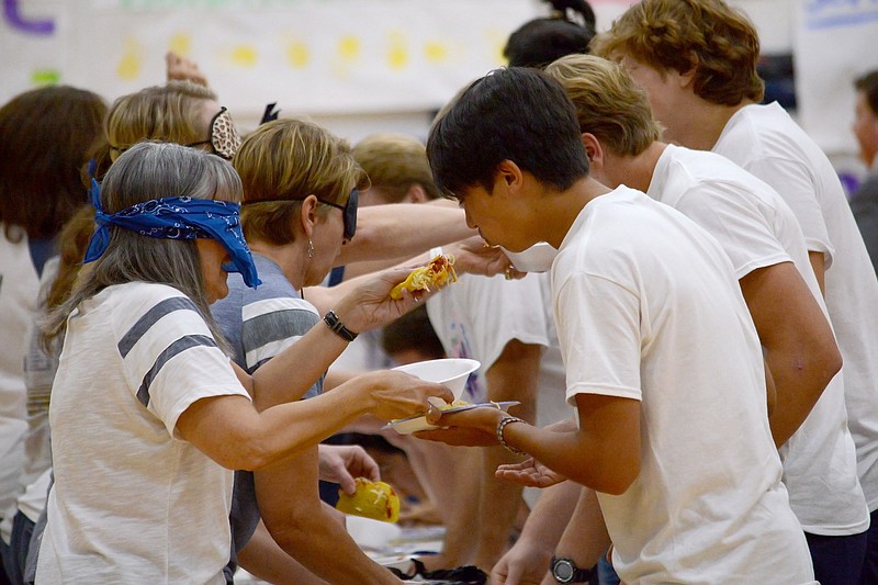 
Mothers of senior football players feed their sons spaghetti tacoswhile blindfolded Friday September 28, 2018 during the Helias homecoming assembly at Helias Catholic High School. Both mother and son also had to stop and dance every time music was played. The first player to finish their plate of tacos won the homcoming taco challenge. 