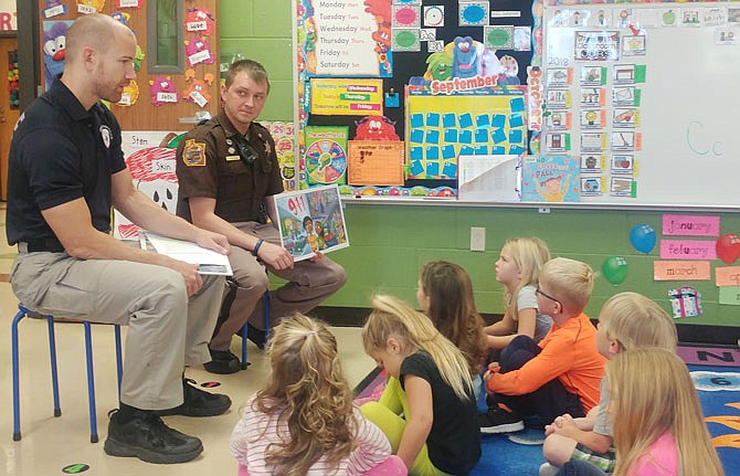 Fredericktown Police Department officer Mike Tiefenauer, left, and Miller County Sheriff's Department Deputy Andy Wickham explain Thursday morning to preschool students at St. Martin School when and when not to call 911. 