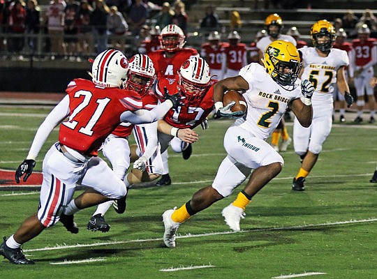 Rock Bridge running back Nate Peat sprints past Jays linebacker Ryan Brooks (17) and cornerback Khalil Foster (21) during a 43-yard touchdown run in the first quarter of Friday night's game at Adkins Stadium.