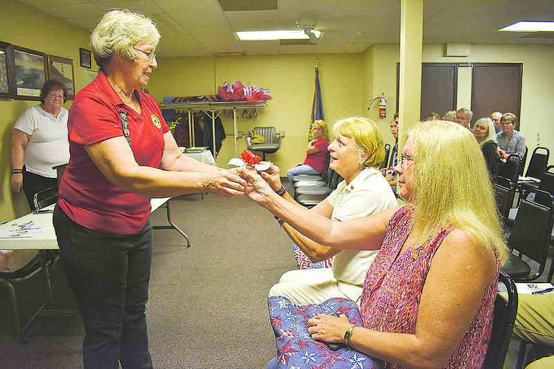 From left, Dorothy Goodin presents Sandy Deraps and Lisa Corbet with poppies Sunday, Sept. 30, 2018, to place on the American Legion Auxiliary's 100th anniversary Poppy Drive poster. Deraps and Corbet were honored at Gold Star Mother's Day at the American Legion Post 5 for their sons' sacrifices.