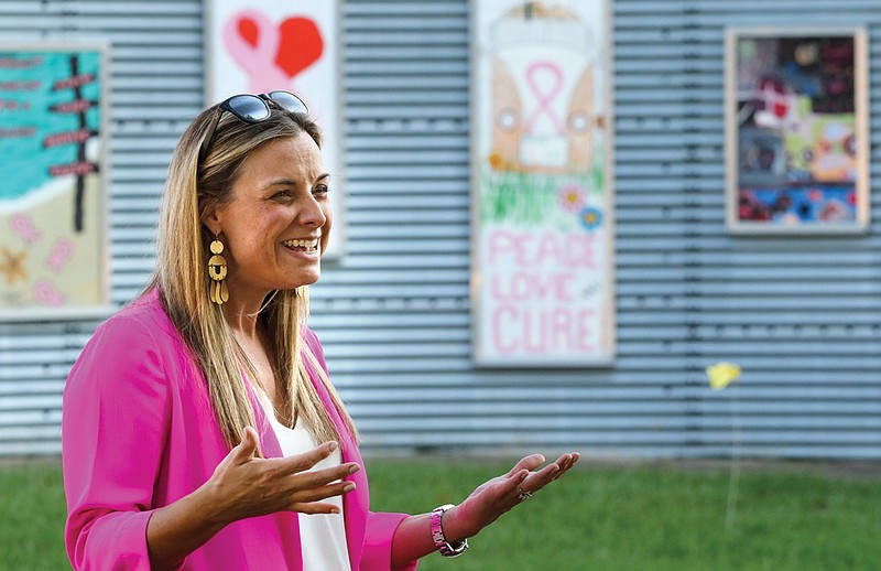 Komen Arkansas' Southwest Region director Amber Lawrence speaks to the public Monday about the paintings at the Art Wall in downtown Texarkana, Texas. The paintings were made by survivors of breast cancer and their supporters. This is the first year the organizers have opened the art project up to people other than survivors.