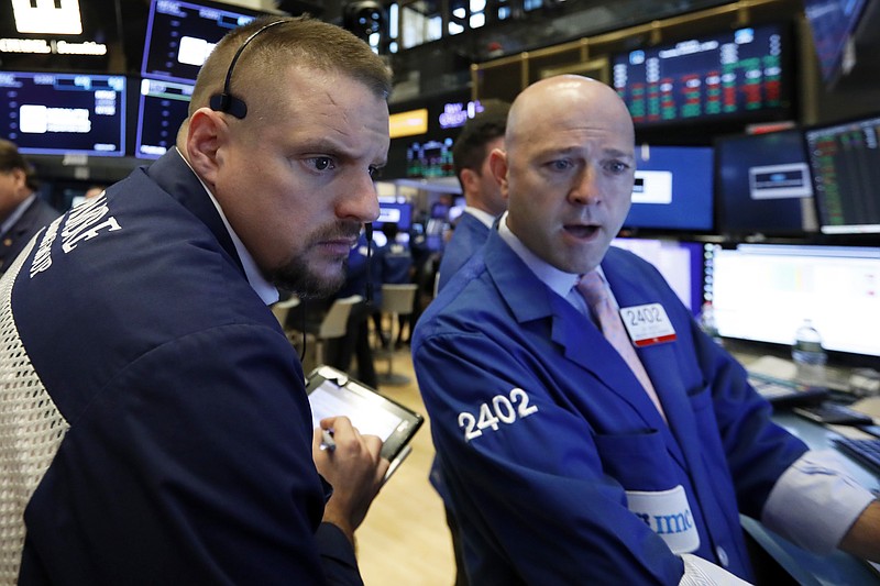 FILE- In this Tuesday, Oct. 2, 2018, file photo trader Michael Milano, left, and specialist Jay Woods work on the floor of the New York Stock Exchange. The U.S. stock market opens at 9:30 a.m. EDT on Wednesday, Oct. 3. (AP Photo/Richard Drew, File)