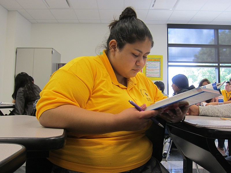 In this Aug. 30, 2018 photo, Lorena Alaniz, a senior at Wisdom High School in Houston, reads a textbook in her Spanish class. Alaniz maintained a 3.5 GPA despite having to work part-time to help her family rebuild their flooded home after Hurricane Harvey. Wisdom and other Houston schools defied expectations and showed improvement in state scores, a feat attributed to perseverance in the face of adversity, and changes to the state accountability ratings that put more emphasis on progress. (AP Photo/Juan Lozano)