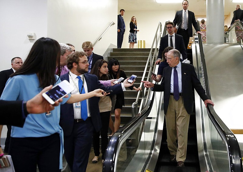 Senate Judiciary Committee Chairman Chuck Grassley, R-Iowa, talks with reporters as he uses the escalator on Capitol Hill, Wednesday, Oct. 3, 2018 in Washington. 