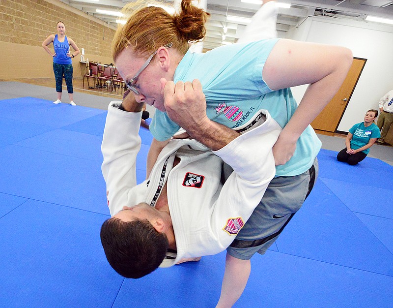 Josh Lehman teaches a technique to Mady Perry on Wednesday during Combat Boots and High Heels a free self-defense class for female service members during at the Jefferson City Athletic Center. Combat Boots and High Heels partnered with the Jefferson City Judo Club to offer the class as part of Domestic Violence Awareness Month.