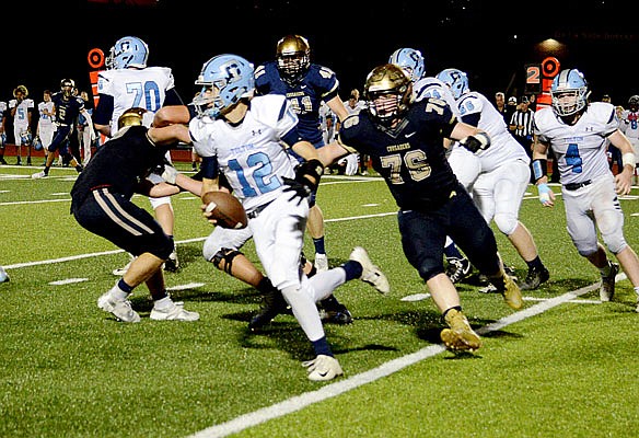 Helias defensive lineman Jim Donovan tries to track down Father Tolton quarterback Robert Hunter during last Saturday night's game at Ray Hentges Stadium.