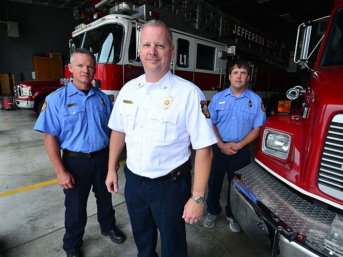 Assistant Chief Jay Niemeyer, center, is flanked by Nick LaBoube, right, and Captain Casey Hughes at Fire Station No. 1 on Thursday. The three firefighters got back Saturday from North Carolina after being deployed to help with Hurricane Florence.