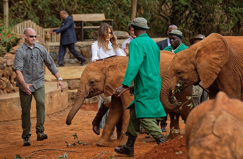 U.S. first lady Melania Trump steps backwards after being nudged by a baby elephant she petted, at the David Sheldrick Wildlife Trust elephant orphanage in Nairobi, Kenya Friday, Oct. 5, 2018.Trump took part in a baby elephant feeding on Friday as she visited a national park in Kenya to highlight conservation efforts. Kenya is the third stop on her Africa tour, which began Tuesday in Ghana and continued in Malawi on Thursday. (AP Photo/Ben Curtis, Pool)