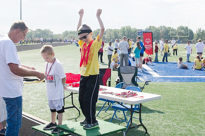 Cameron Jackson raises his hands above his head in celebration after winning the 100-meter dash Friday at the South Callaway Special Olympics. 