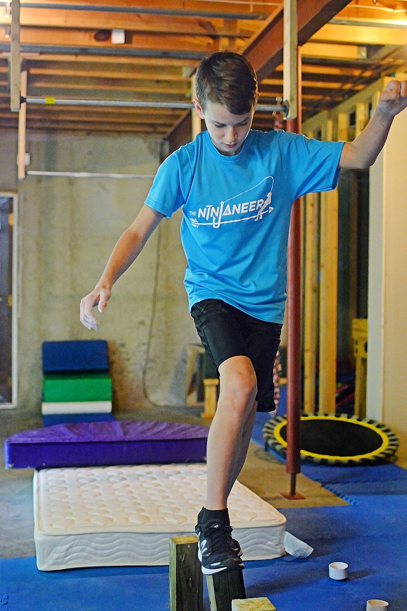 Sally Ince/ News Tribune
12-year-old Jonah Taggart balances on wooden posts Thursday September 20, 2018 at his home gym. Taggart was selected from more than 10,000 applicants from around the nation to be one of 192 children to compete on the first season of American Ninja Warrior Junior.