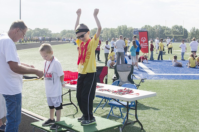 Cameron Jackson raises his hands above his head in celebration after winning the 100-meter dash Friday at the South Callaway Special Olympics. 