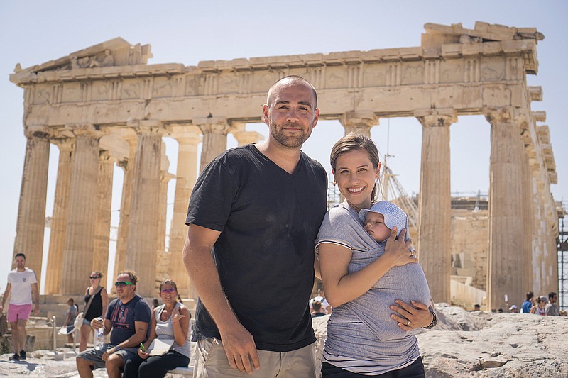 This September 2017 photo provided by Konrad Waliszewski of TripScout shows Waliszewki with his family posing for a photo in front of the Parthenon in Athens, Greece. Waliszewski's son has already been to eight countries in his 16 months of life. (Konrad Waliszewski/TripScout via AP)