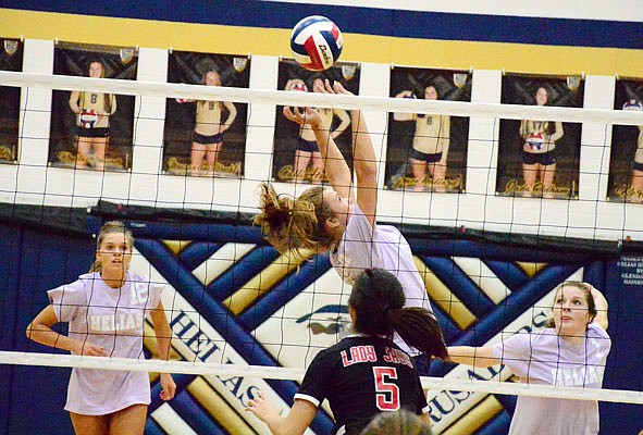 Riley Bernskoetter of Helias sets the ball between teammates Ellie Rockers (left) and Callie Henson as Ella Wang of Jefferson City prepares to defend during Tuesday night's action at Rackers Fieldhouse.