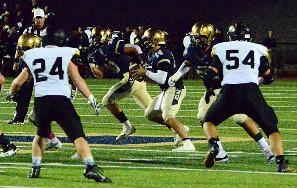 Helias quarterback Jacob Weaver rolls out with the ball during last Friday night's game against Monroe City at Ray Hentges Stadium.