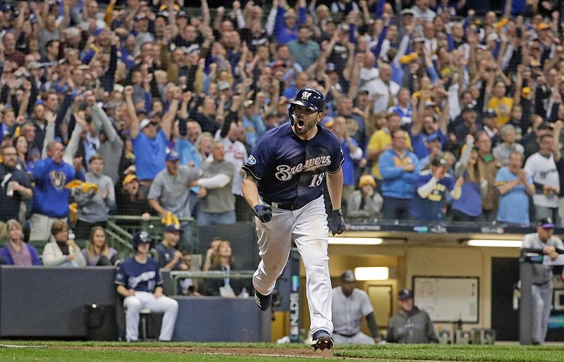 Mike Moustakas of the Brewers reacts after hitting an RBI single during the eighth inning of last Friday's Game 2 of the NLDS against the Rockies in Milwaukee.
