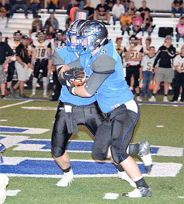 South Callaway senior quarterback Peyton Leeper hands the ball off to senior running back Bradyn Belcher during the Bulldogs' 69-0 Eastern Missouri Conference rout of Van-Far/Community last Friday in Mokane. South Callaway travels tonight to Wright City.