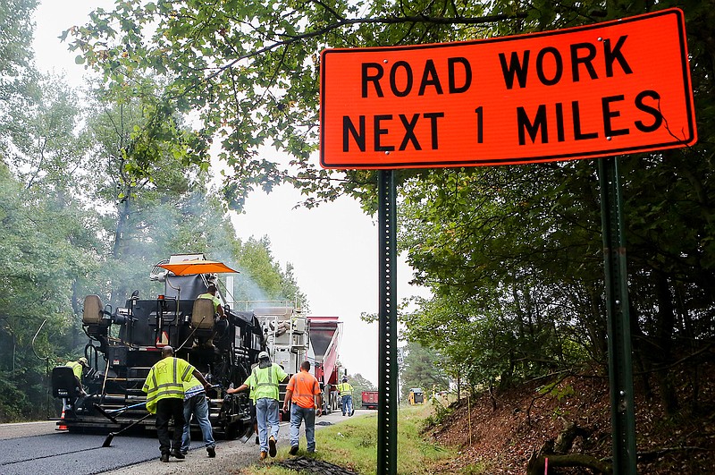 Construction workers from Redstone Construction Group work on repaving U.S. Highway 371 on Tuesday in Lockesburg, Ark. Redstone was awarded the project for $3.48 million to overlay Highways 71 and 371 in Miller, Little River and Sevier counties. Sections of the highways are being overlaid with ultra-thin bonded wearing course that will seal the pavement underneath to help prevent the need to repair the road.