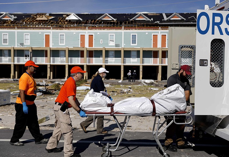 A body is removed after being discovered during the search of a housing structure in the aftermath of hurricane Michael in Mexico Beach, Fla., Friday, Oct. 12, 2018. (AP Photo/David Goldman)