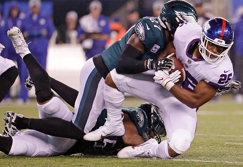 New York Giants running back Saquon Barkley (26) is tackled by Philadelphia Eagles' Malcolm Jenkins (27) during the first half of an NFL football game Thursday, Oct. 11, 2018, in East Rutherford, N.J. (AP Photo/Julio Cortez)